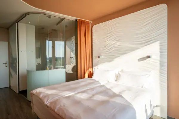 Bed met een glazen wand op de achtergrond