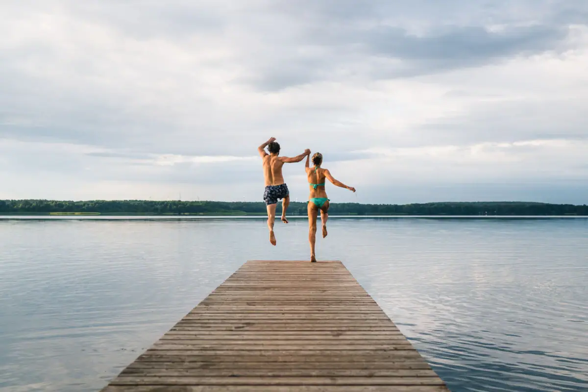 Een man en een vrouw springen in het water.