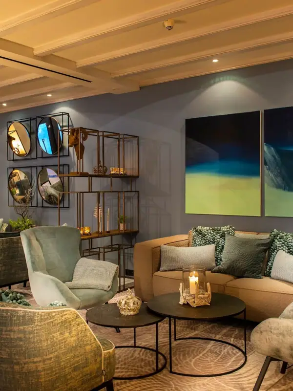 Een kamer met een bank en stoelen.