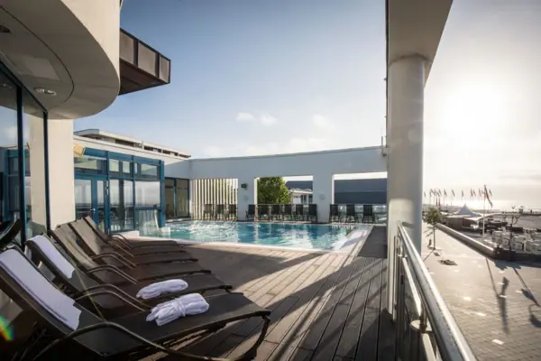 aja Grömitz buitenzwembad Een zwembad met ligstoelen en een terras in de spa van het aja Grömitz, oftewel de Grömitzer Welle...