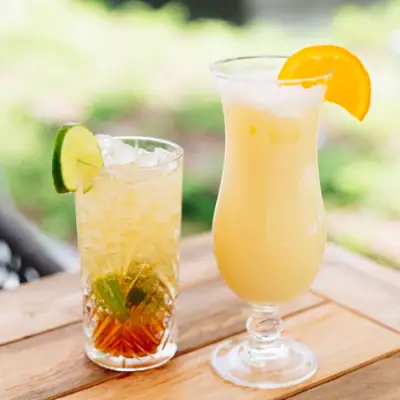 Twee glazen met drank op een tafel, één met een cocktailset.