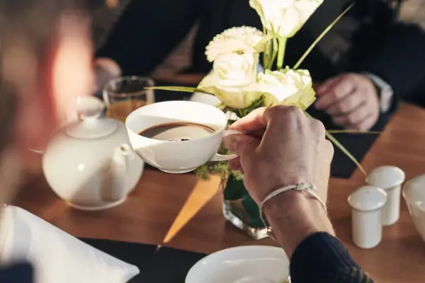 Een persoon houdt een kop koffie vast.