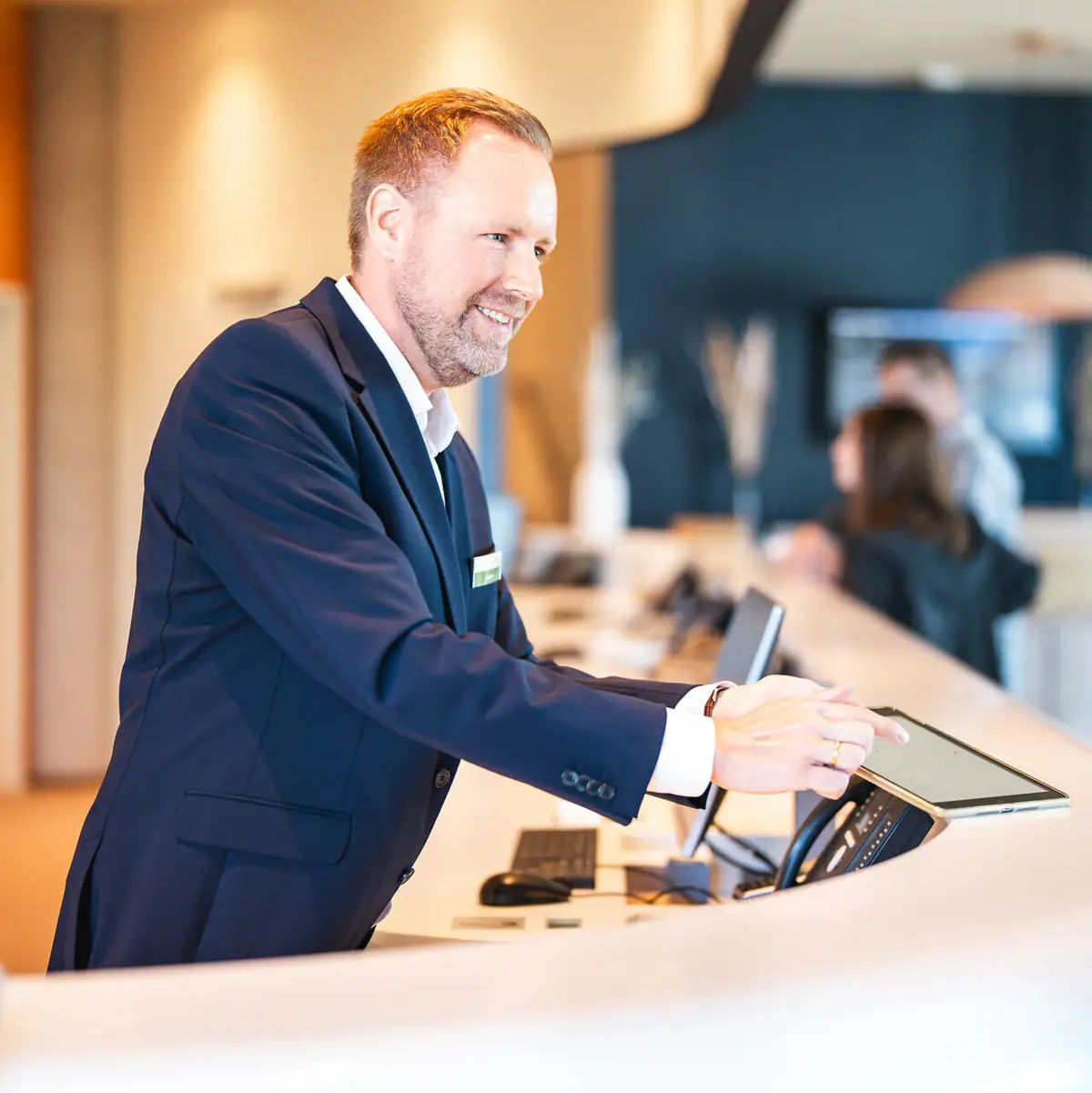 Receptie Een man staat bij een toonbank.