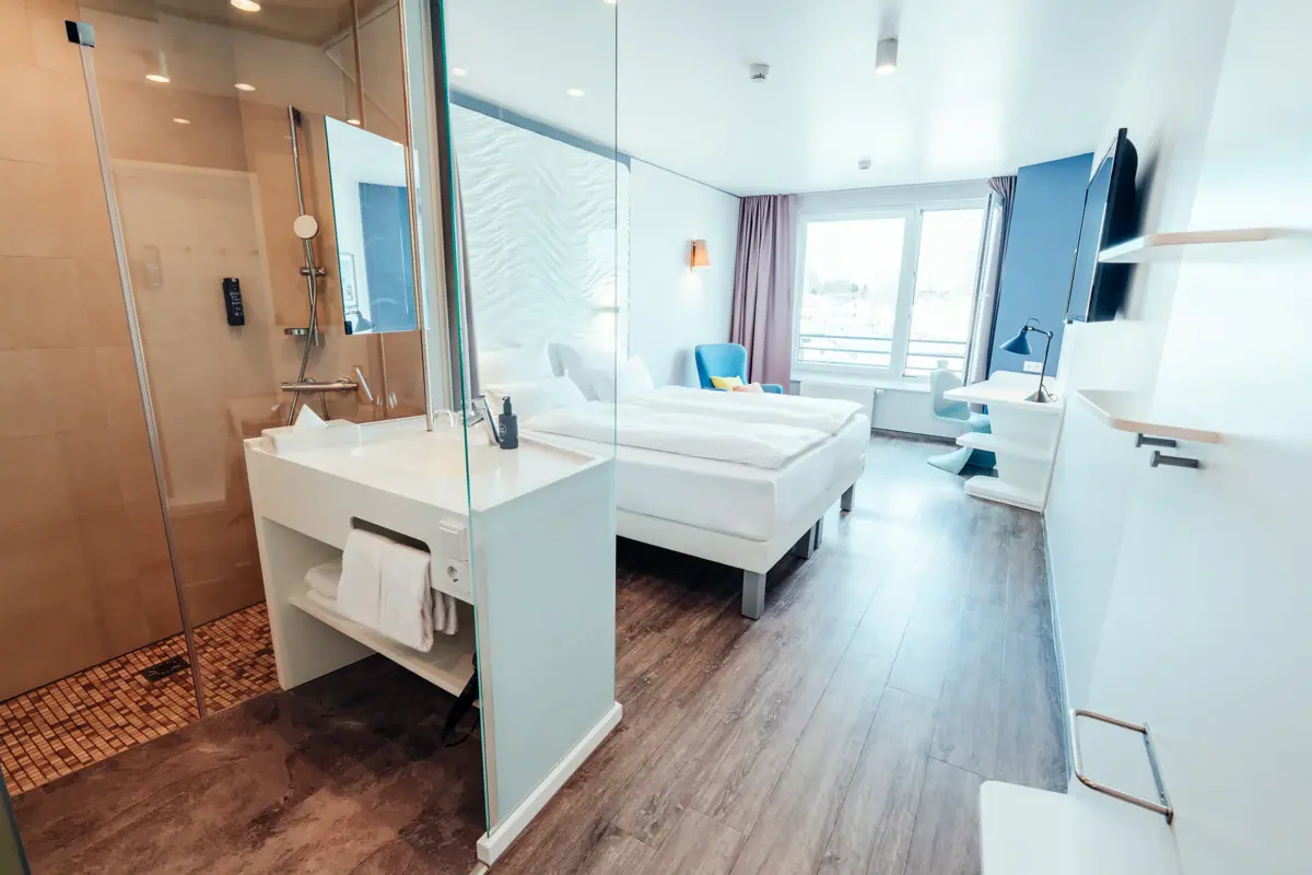 Een kamer met twee bedden en een douche.