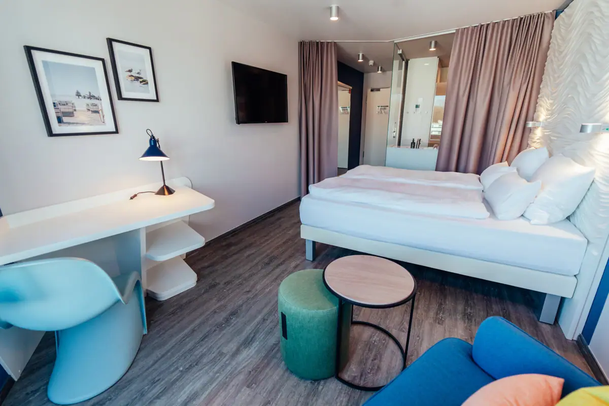 Een kamer met een bed, tafel en stoel.