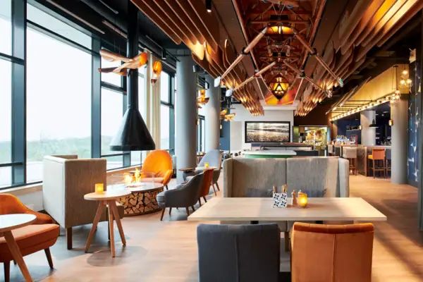 Restaurant en bar bij aja Warnemünde Een restaurant met tafels en stoelen, modern ingericht.