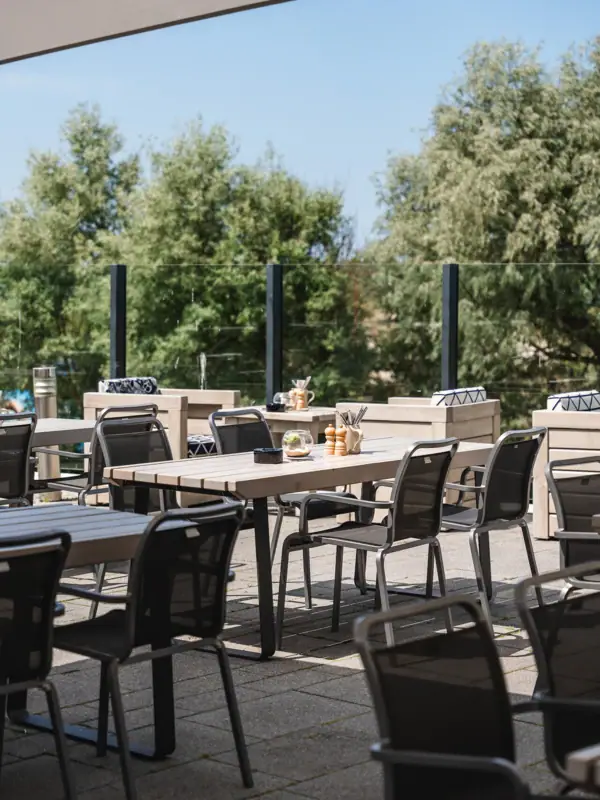 Restaurant en bar bij aja Warnemünde Een tafel en stoelen op een terras.