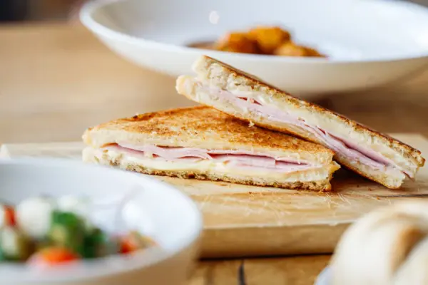 Broodje bij het badhuis van Werfenweng Gegrilde kaassandwich op een houten plankje