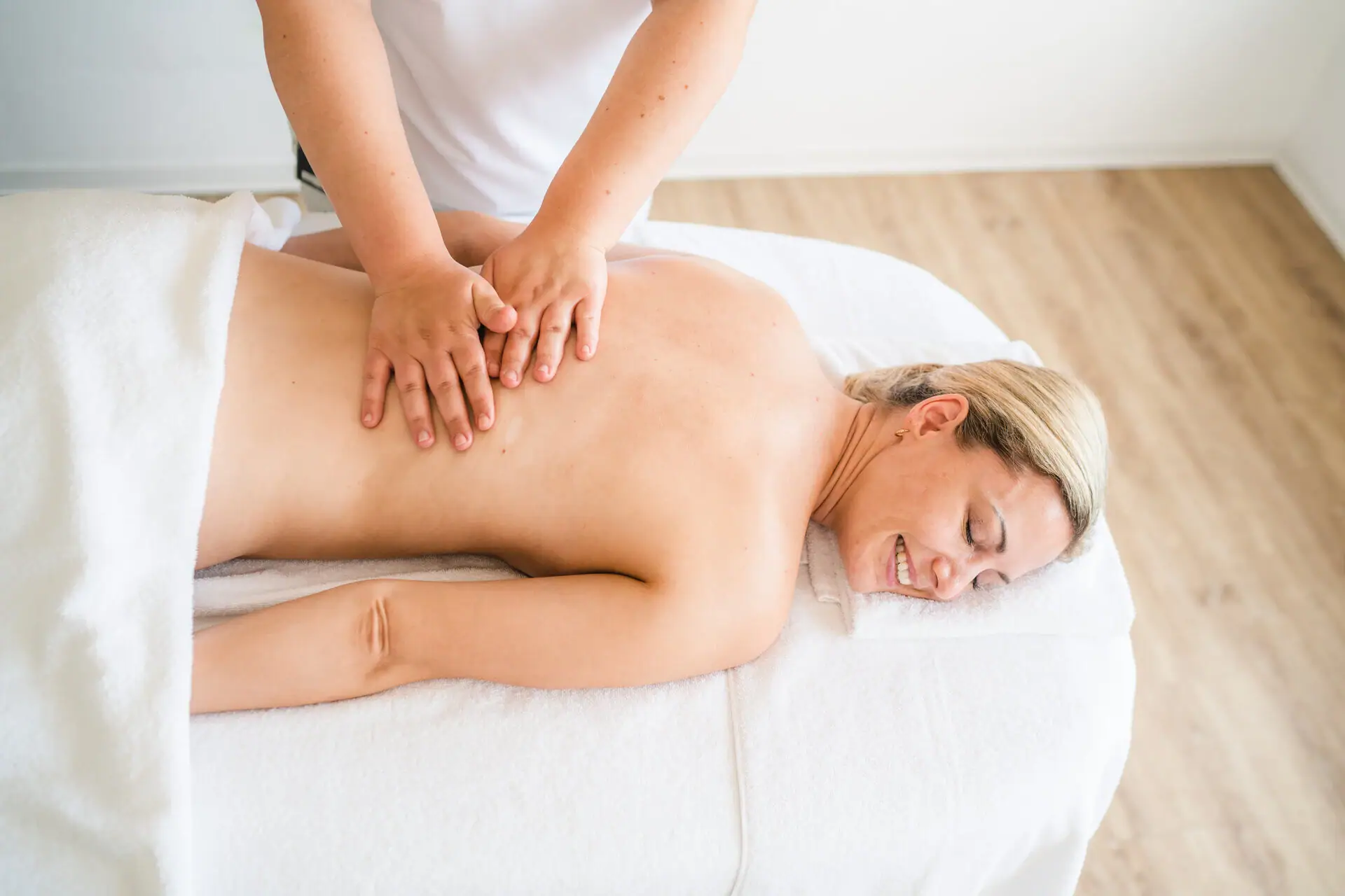 Een vrouw ligt op een massagetafel.