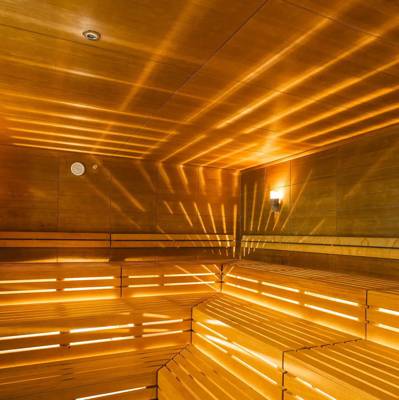 Sauna bij aja Bad Saarow Houten sauna met licht dat door de muren schijnt.