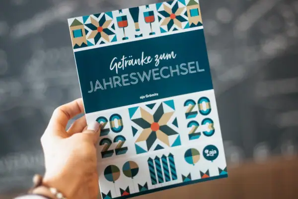 Eén hand houdt een programmaboekje vast voor het nieuwjaarsfeest.