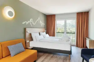 Tweepersoonskamer bergzicht aja Ruhpolding Een kamer met twee bedden en een bank.