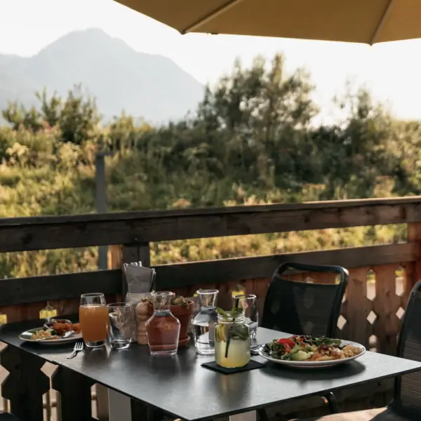 Een terras van het aja Familienhotel Bayern met uitzicht op de bergen.