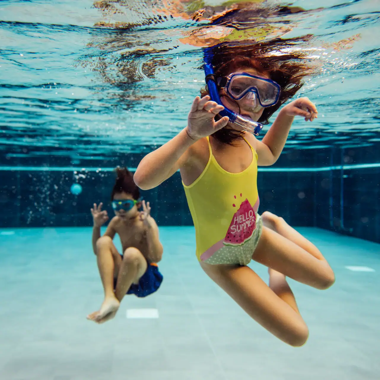 Kinderen in het zwembad Twee kinderen zwemmen onder water in een zwembad.