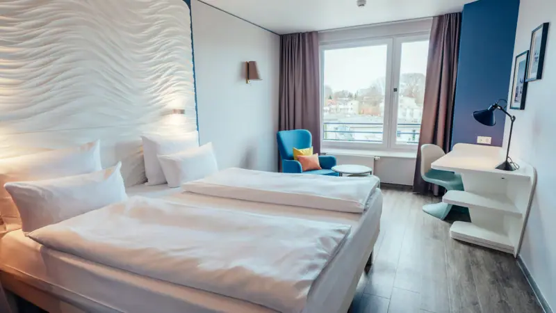 Een kamer met twee bedden en een tafel.