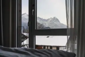 Blick aus einem Fenster auf schneebedeckte Berge