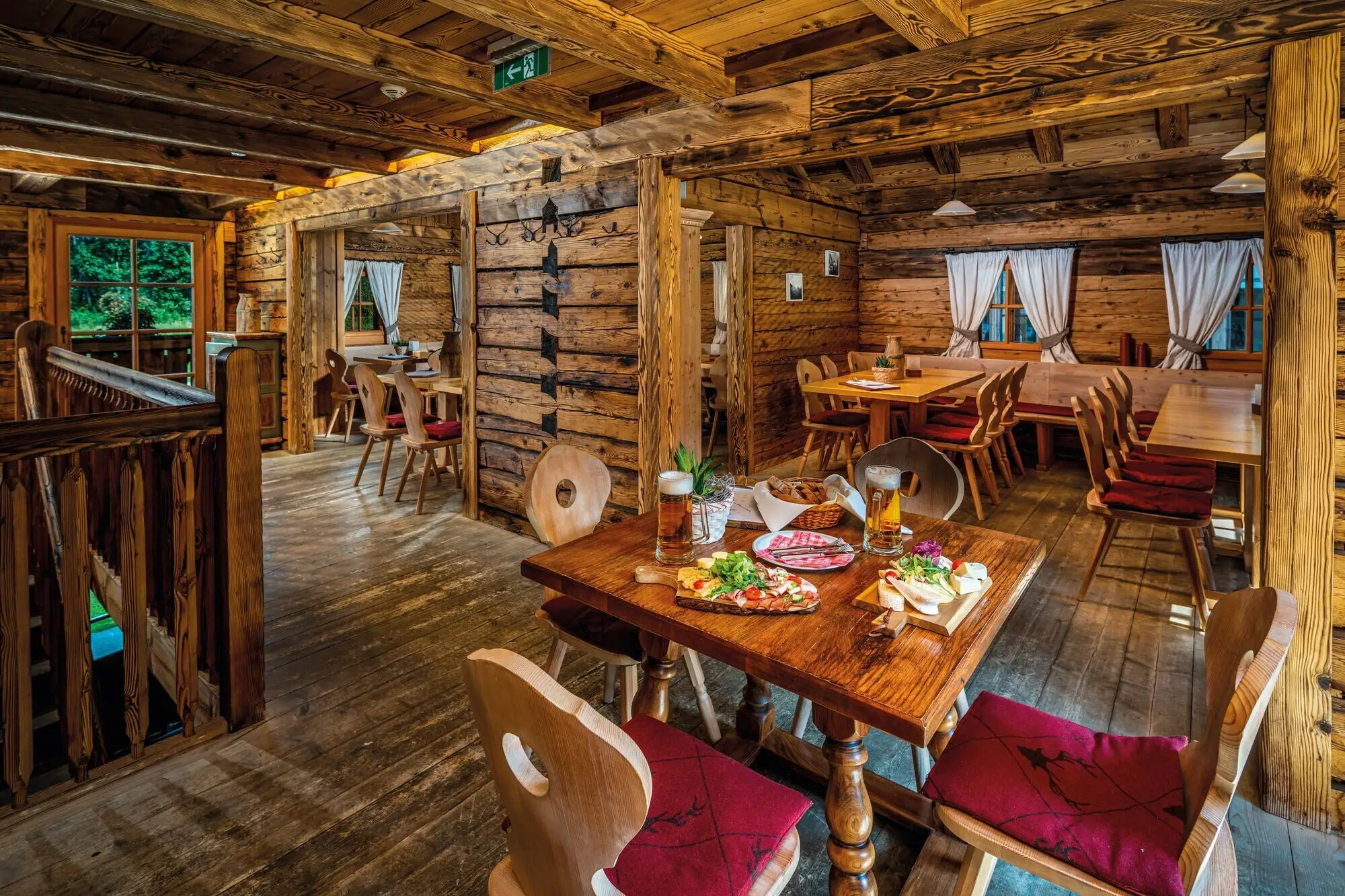 Een eetzaal met tafels en stoelen en een tafel met eten.