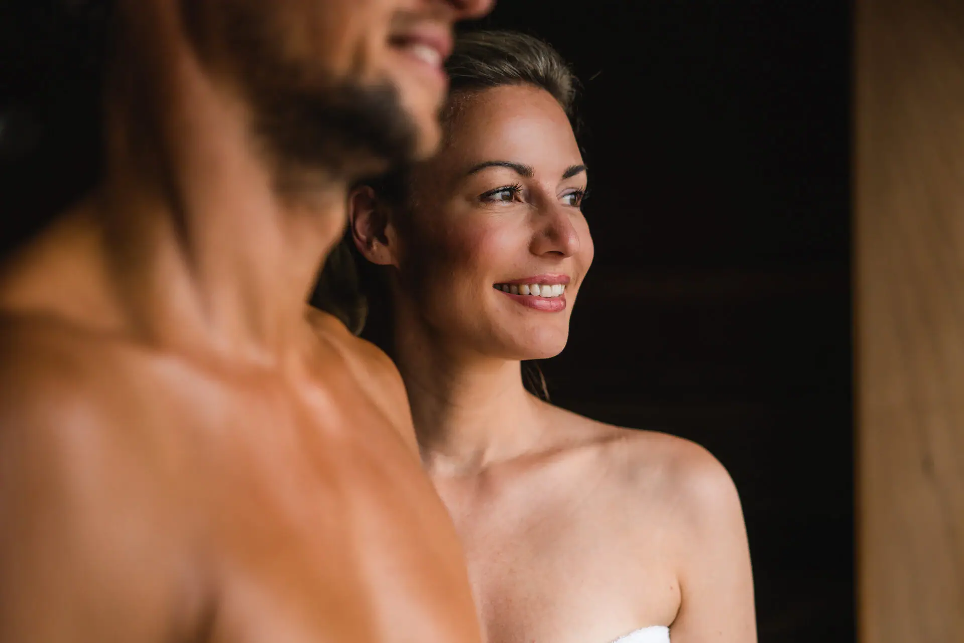 BIO sauna bij aja Warnemünde Een man en een vrouw staan lachend in een sauna.