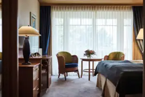 Tweepersoonskamer Een kamer met een bed, een tafel en stoelen.