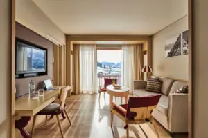 Een kamer met een tafel, stoelen en een televisie.