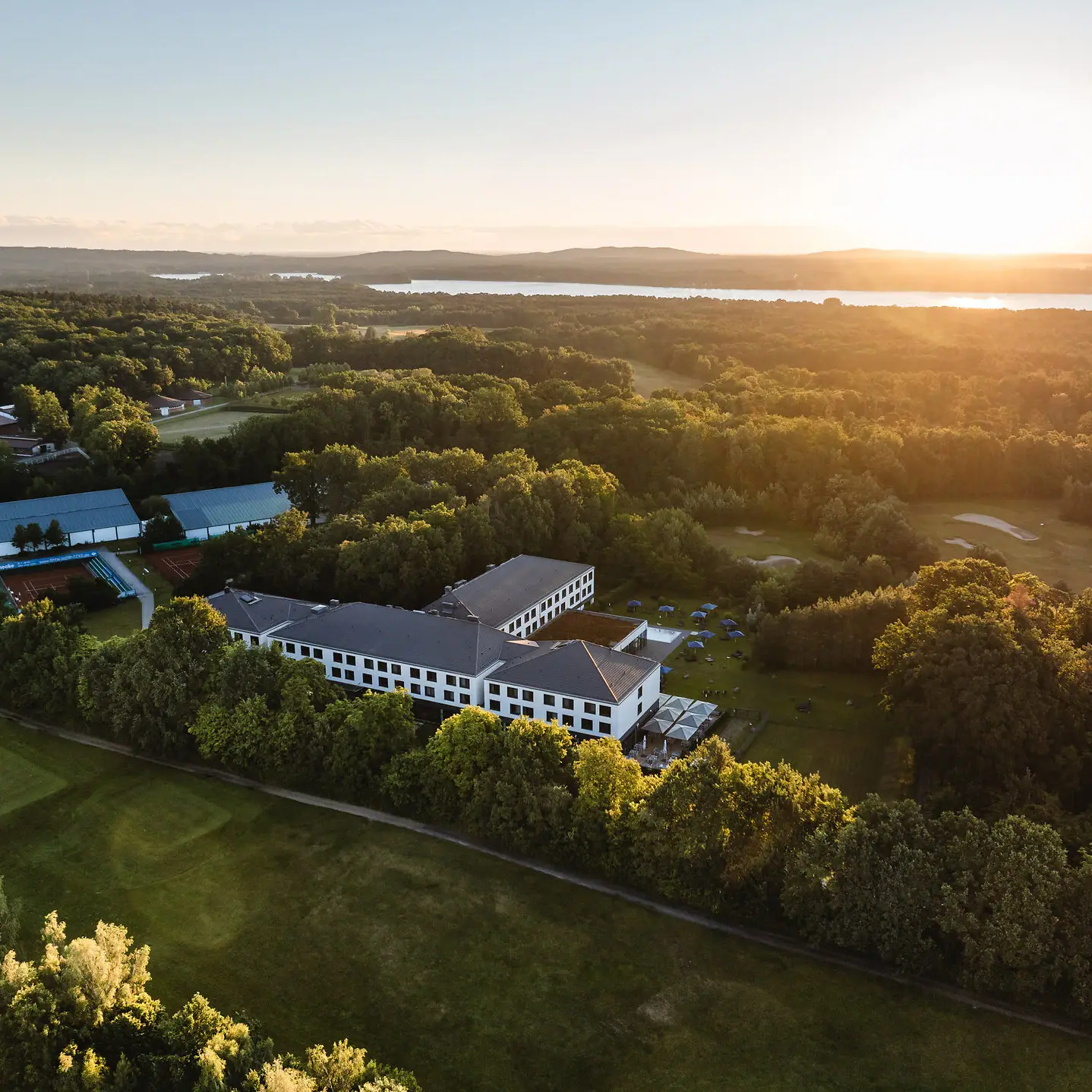 aja Bad Saarow Een gebouw omringd door bomen en water.