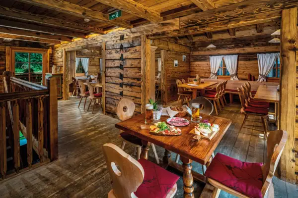 Een eetzaal met tafels en stoelen en een tafel met eten.