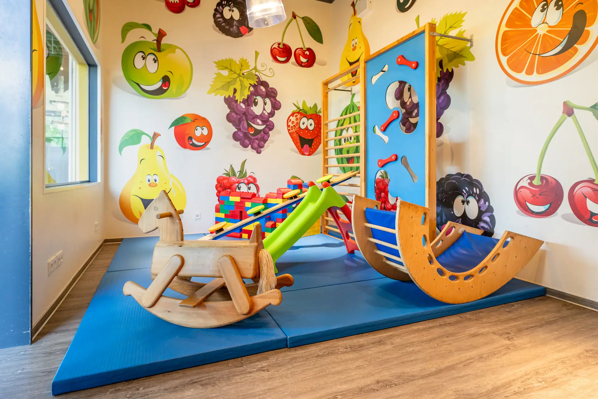 Kinderhoek aja Bad Saarow Speelruimte in een kamer met kinderkunst aan de muur.