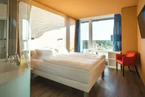 Kamers in het aja Warnemünde Een kamer met een bed, een bureau en een stoel.