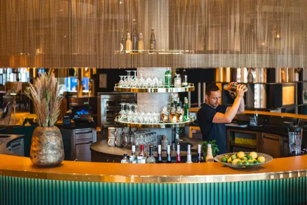 Een man schenkt een drankje in in een bar.