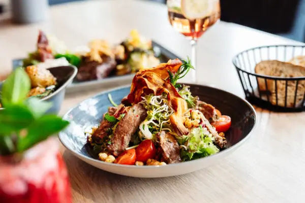 Ein Teller mit Salat, Fleisch und Gemüse.