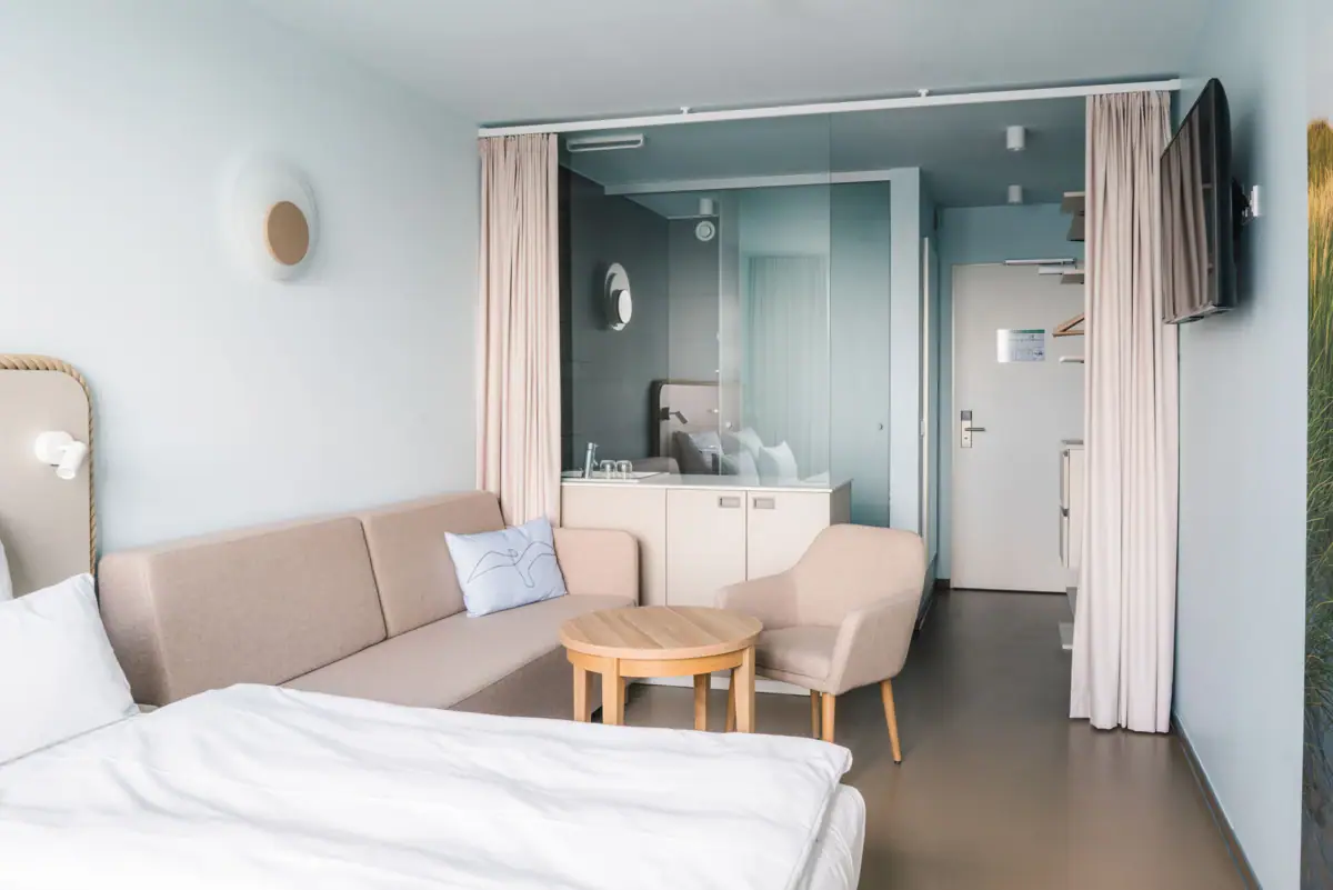 Kamers in het aja Travemünde Een kamer met een bank en een tafel.
