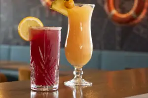 Zwei Gläser mit Getränken auf einer Bar.