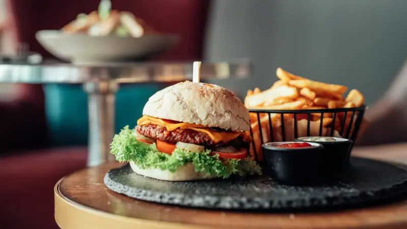 Een burger en frietjes op een tafel.