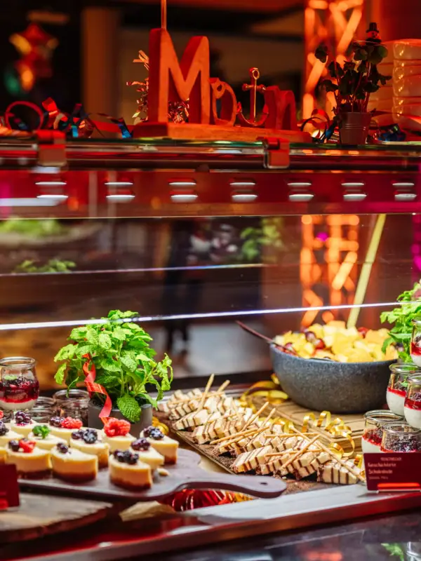 Dessertbuffet bestaande uit plakjes cheesecake met fruit en een toetje met chocoladecrème