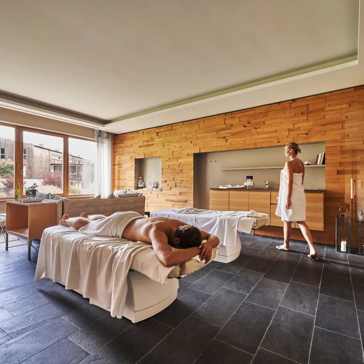 Massage Een man ligt op een bed terwijl een vrouw achter hem staat.