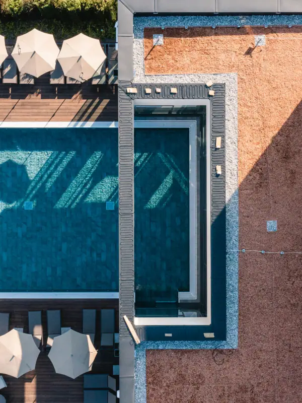 Buitenzwembad van bovenaf Zwembad en parasols op één dak