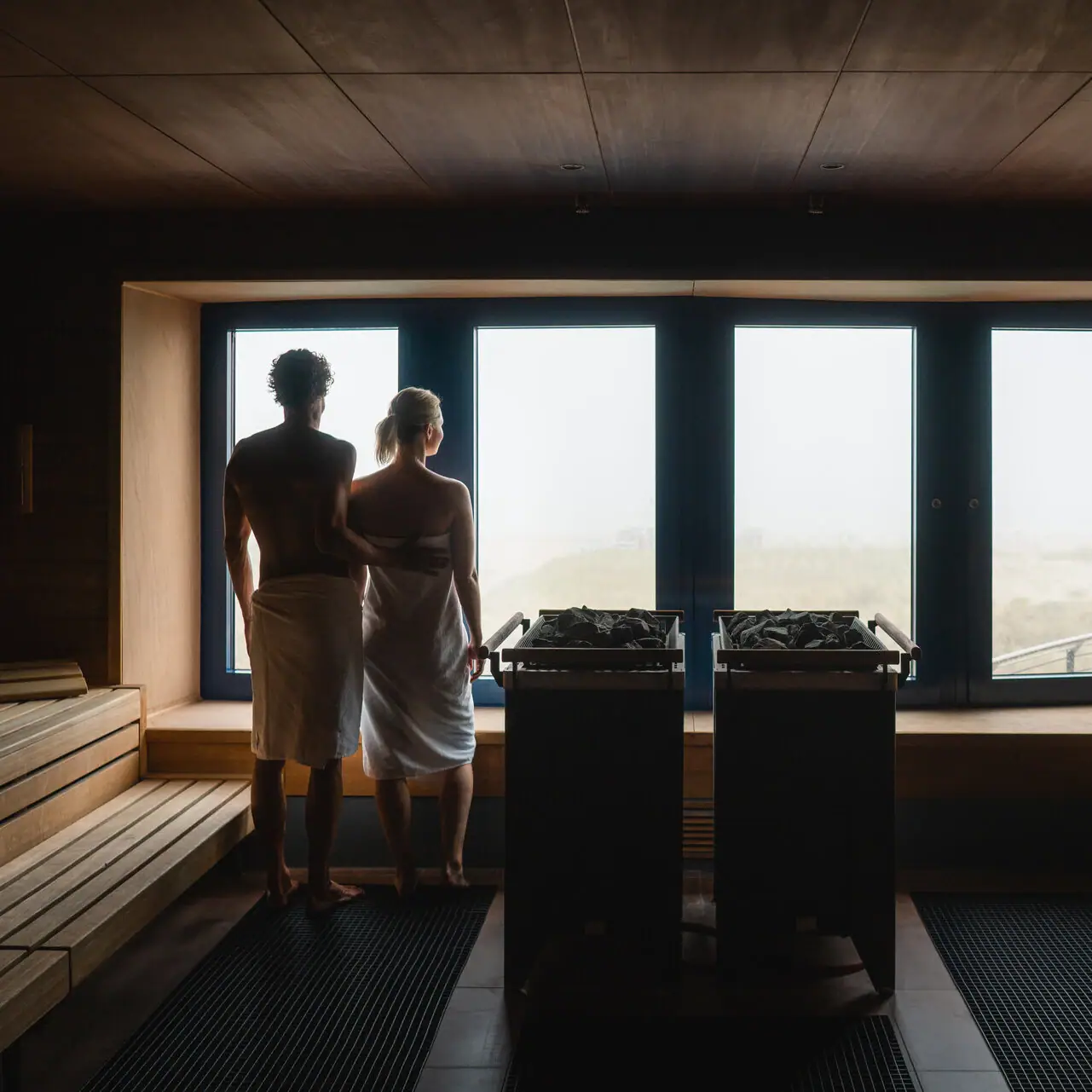 Een man en een vrouw staan in een sauna.