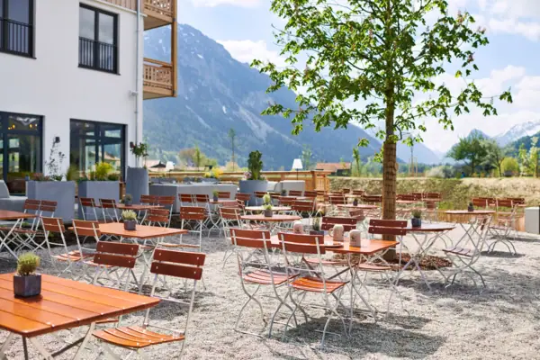 Biertuin in Ruhpolding Een groep tafels en stoelen buiten voor de aja Ruhpolding.