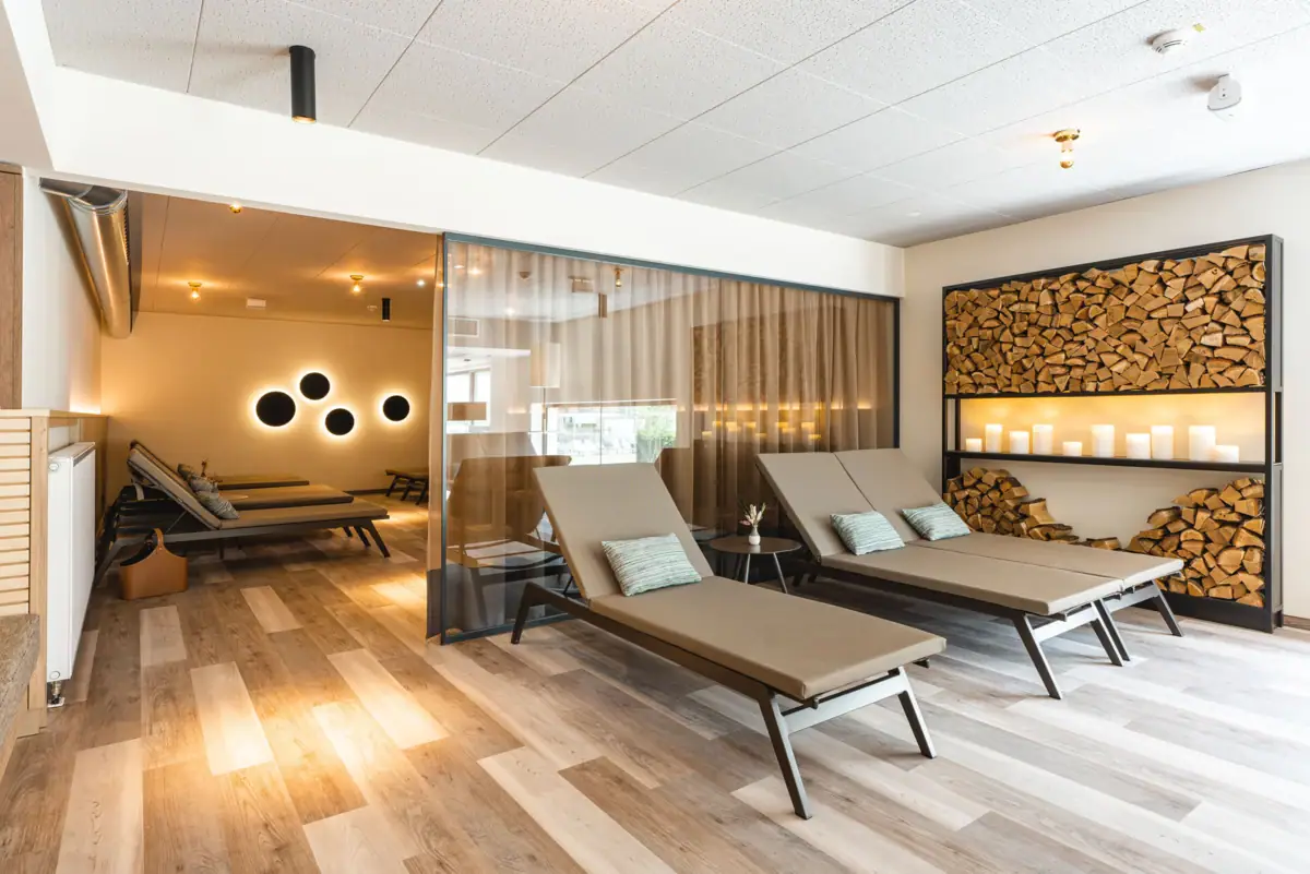 Ontspanningsruimte Een kamer met loungestoelen en houten planken.