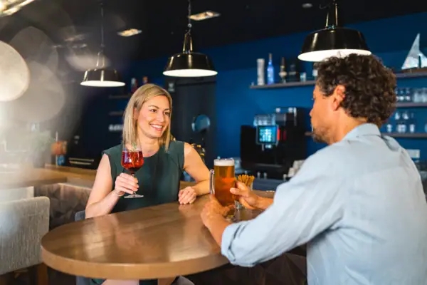 aja Bar bij aja Warnemünde Een man en een vrouw zitten aan een tafel met drankjes.