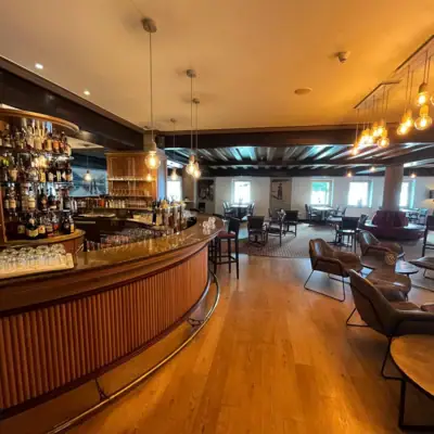 Eine Bar mit Tresen und Stühlen.