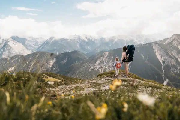 Een gezin tijdens een wandeling in Beieren, met bergen op de achtergrond.