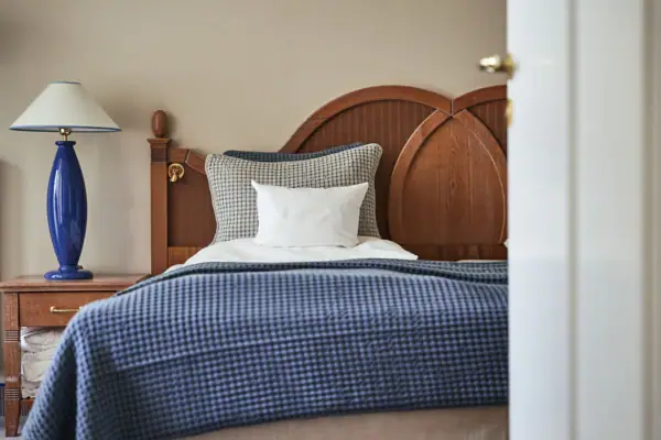 Bed met blauwe deken en wit kussen