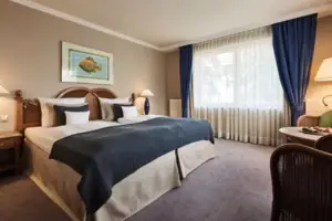 Tweepersoonskamer Een slaapkamer met een bed en een lamp.