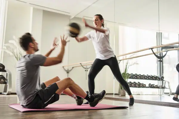 Een man en een vrouw trainen in een sportschool.