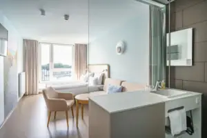 Tweepersoonskamer Een kamer met een bed en een bank.