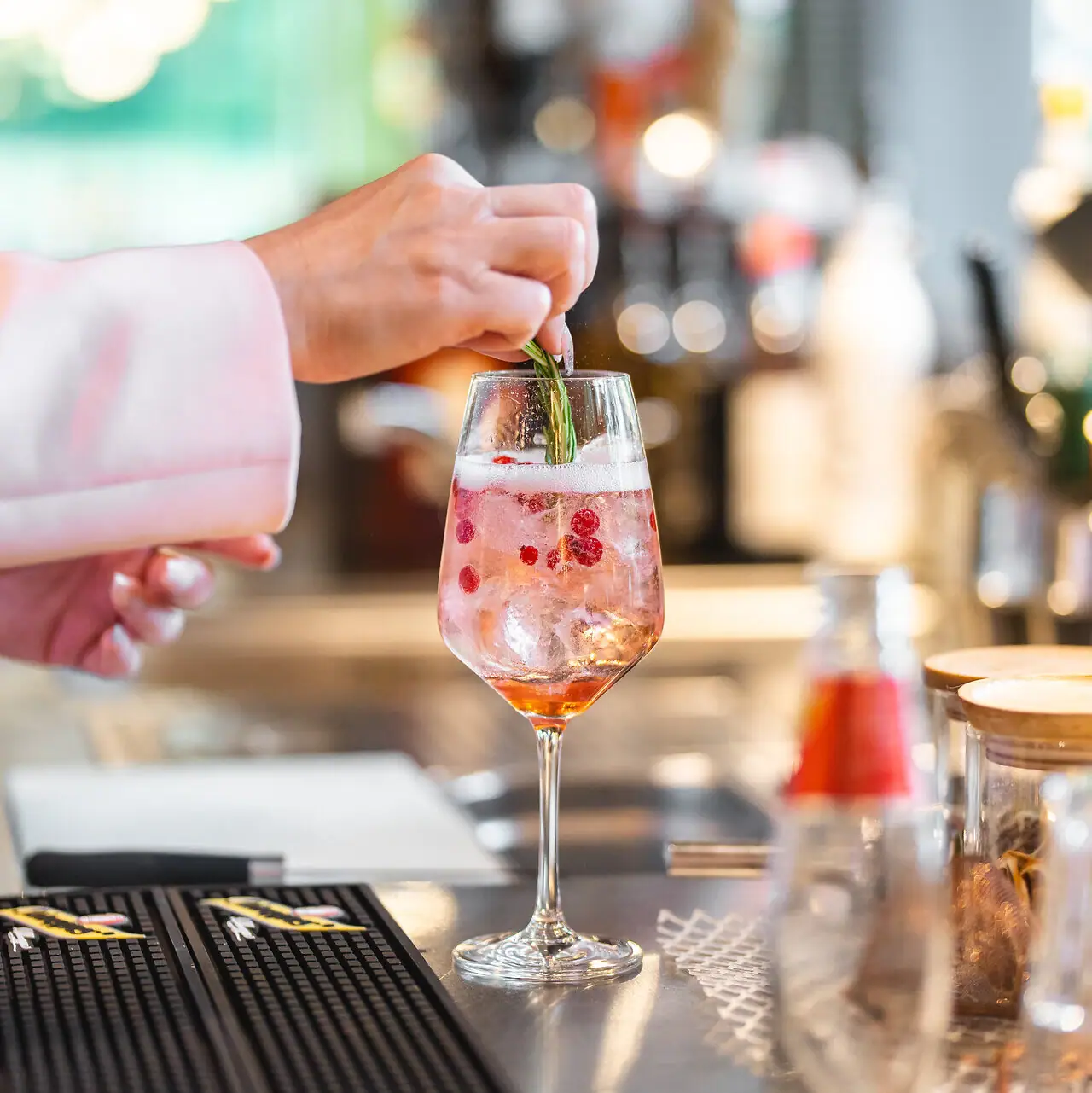 Aperitief Eén persoon legt een blad op een drankje in een glas.