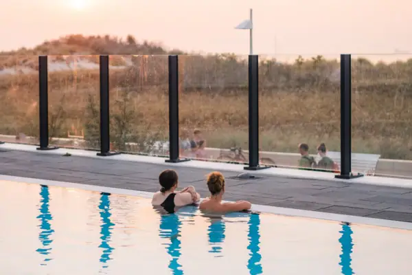 Twee mensen zwemmen in een zwembad.