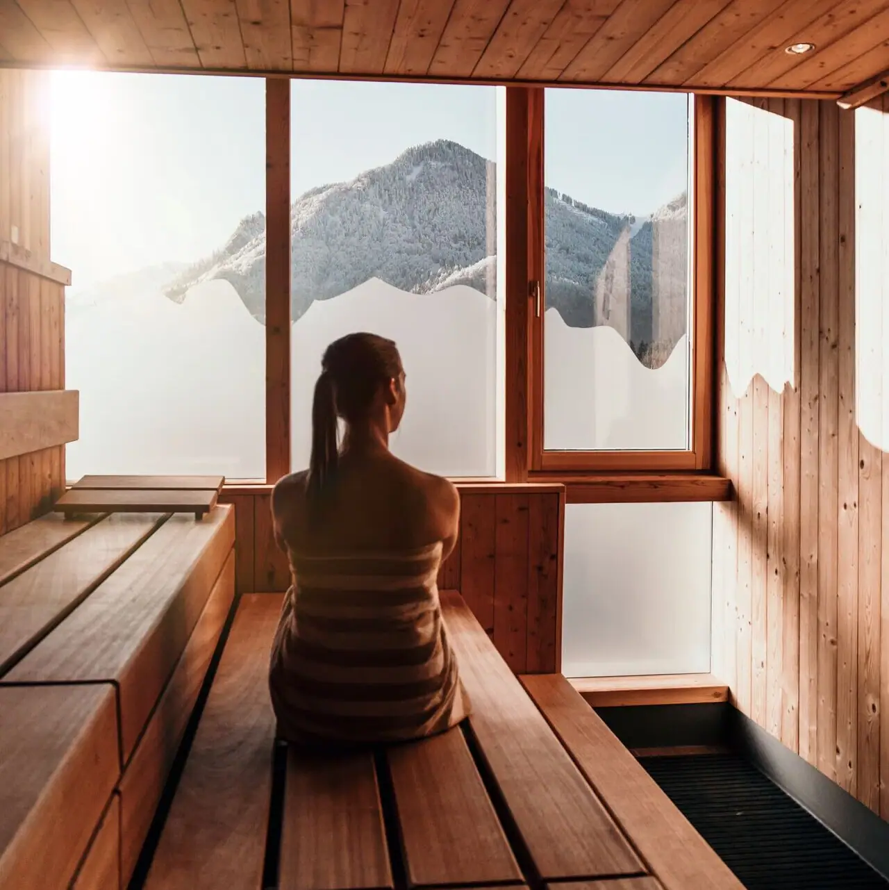Sauna bij aja Ruhpolding Een vrouw zit in een sauna.