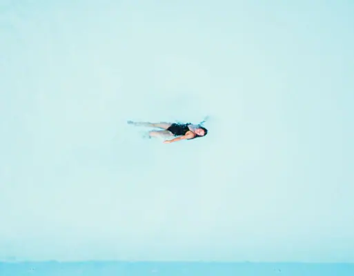 Zwemmen in het zwembad Een vrouw zwemt op haar rug in het zwembad.